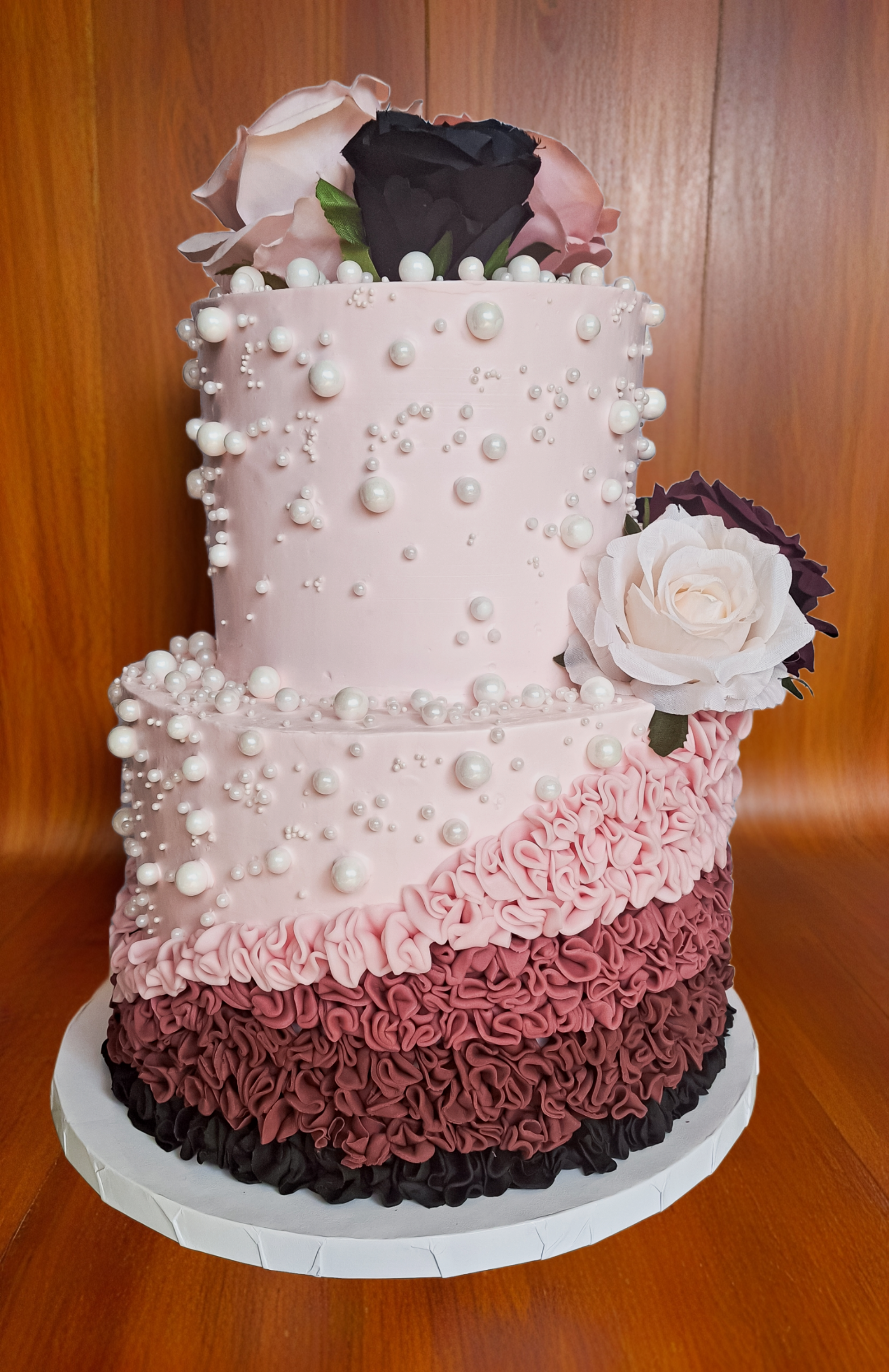 Three-tiered pink ombre ruffle cake with pearl embellishments and rose topper