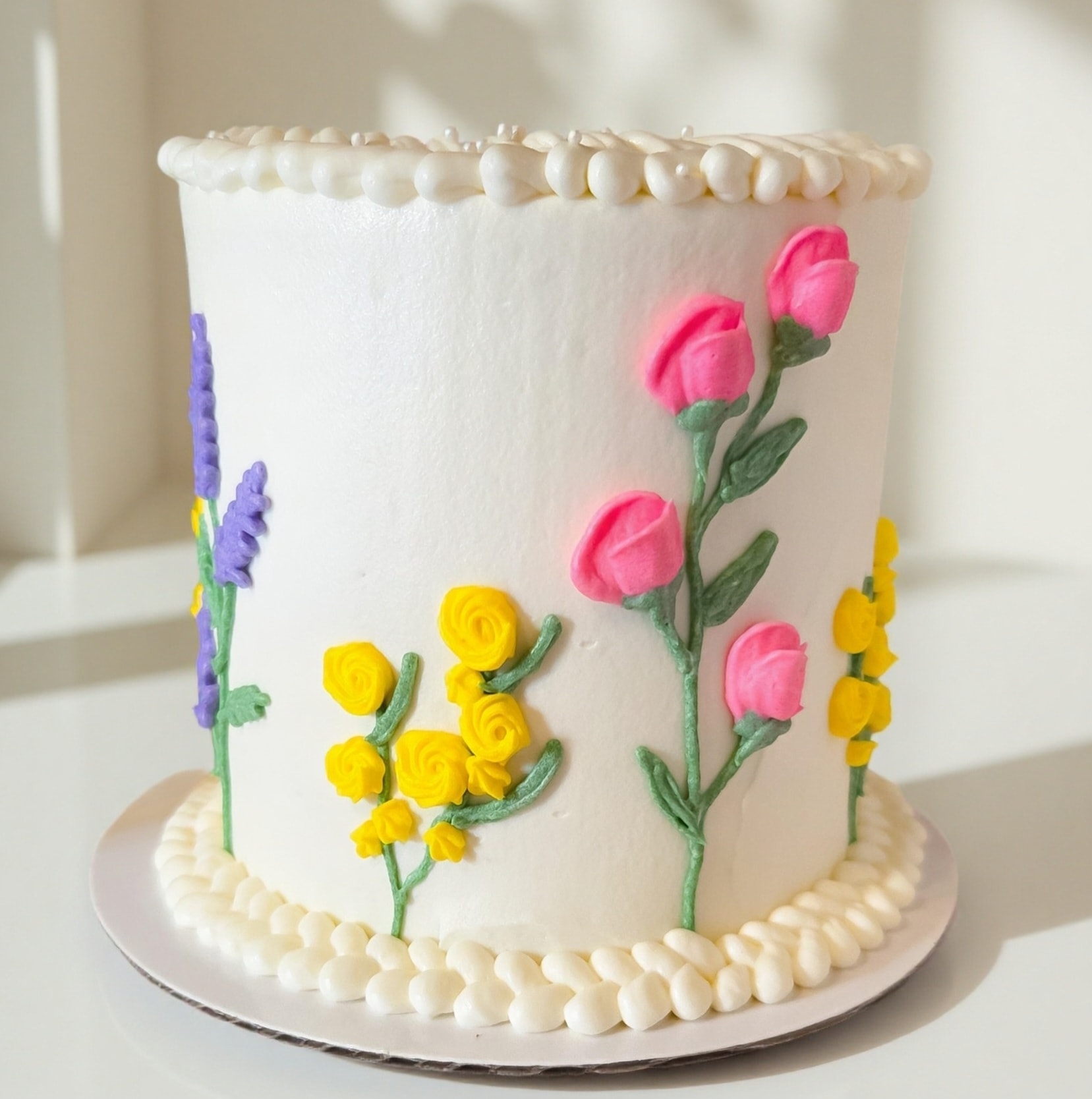 White cake with colorful fondant flowers
