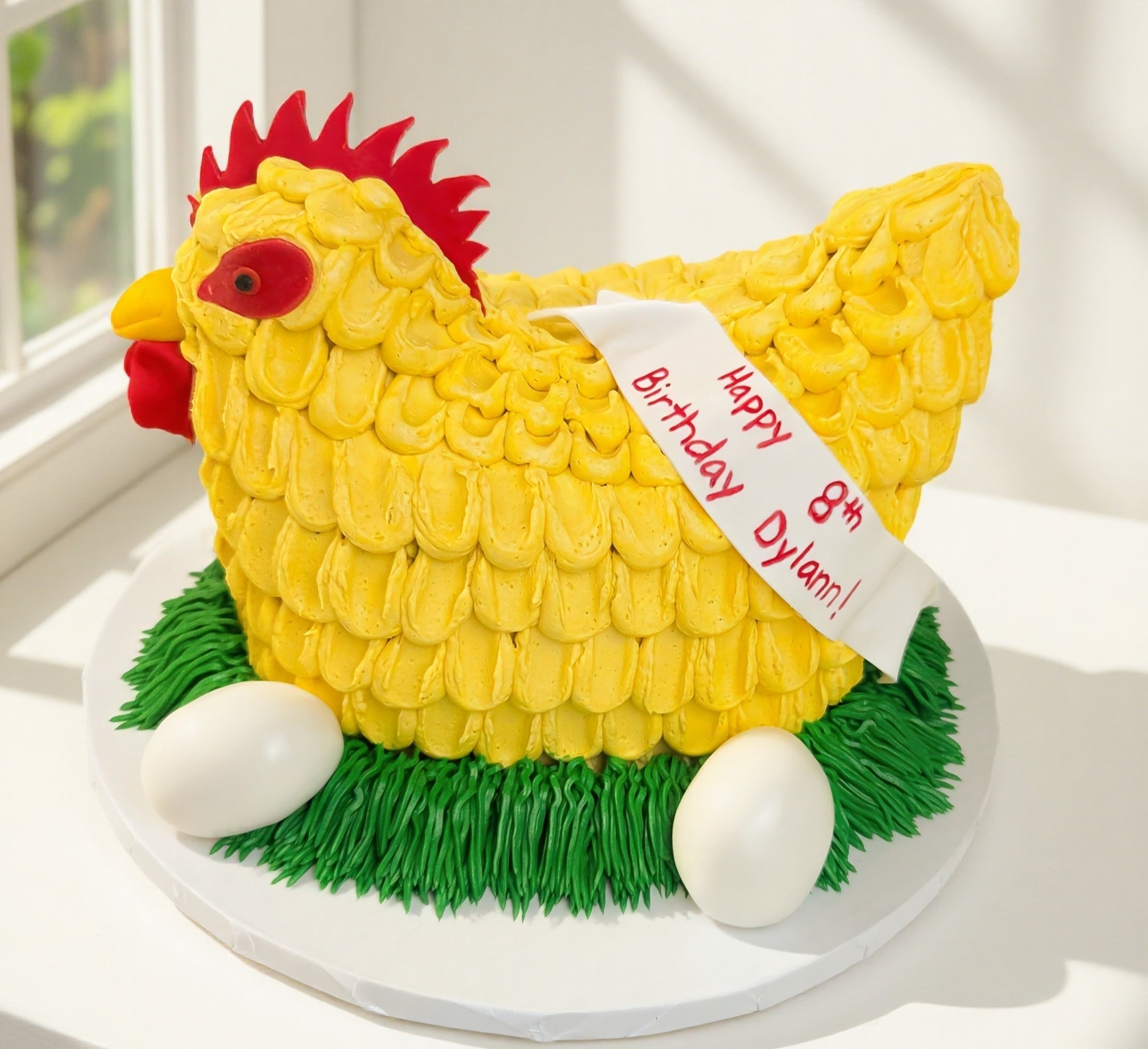 Yellow hen shaped birthday cake with eggs